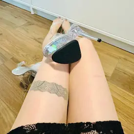 A clear platform high heel on Lady Samantha's thighs with lace skirt and her thigh band tattoo - Foot Fetish Zurich